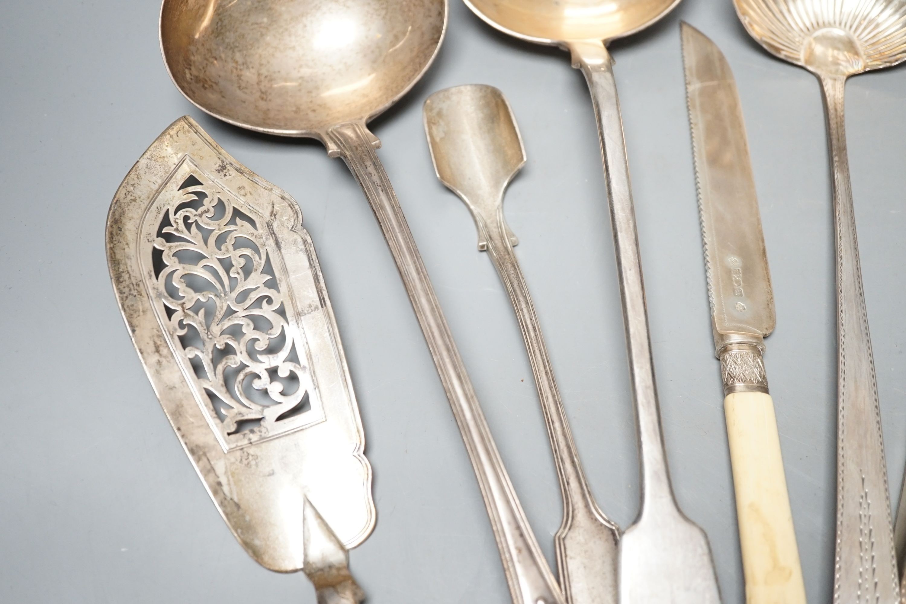 A George III Irish silver Celtic tip soup ladle, Dublin, 1789, A Georgian Irish silver marrow scoop, by William Walsh, two later Victorian silver soup ladles, a pair of Victorian silver asparagus tongs, two silver bastin